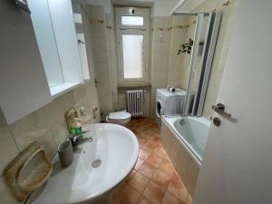 łazienka z umywalką, toaletą i wanną w obiekcie Cozy Apartment x6 persone w Turynie