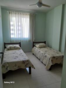 1 dormitorio con 2 camas y ventilador de techo en Praia de Piedade, en Recife