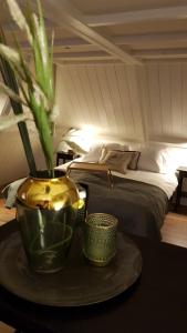 Un dormitorio con una cama y una mesa con un jarrón. en Anna's Zusje Boetiekhotel en Harlingen
