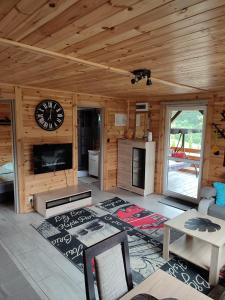 a living room with a clock on a wooden wall at Roztocze, Domek Na Leśnym Wzgórzu nr2,Krasnobród,Zamość, Zwierzyniec, jacuzzi in AdamÃ³w