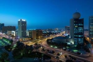 a city skyline at night with traffic on a street at Sheraton Dubai Creek Hotel & Towers in Dubai +98 photos