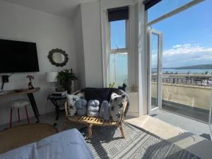 ein Wohnzimmer mit einem Stuhl und einem großen Fenster in der Unterkunft Seadream Luxury Holiday Home with Hot Tub Sleeps 6 in Scarborough
