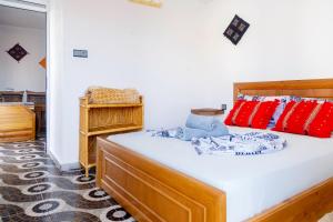 a bedroom with a bed with red and blue pillows at The Rina Hostel in Agadir