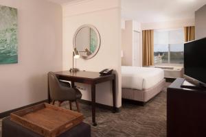 a hotel room with a desk and a bed and a mirror at SpringHill Suites Orlando Airport in Orlando