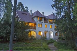 a large white house with its lights on at Willa Zameczek in Polanica-Zdrój