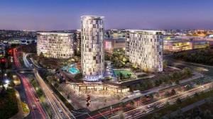 a city with two tall buildings and traffic at night at Ellipse Waterfall luxurious unit in Midrand