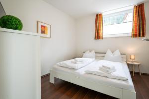 ein weißes Bett in einem Zimmer mit Fenster in der Unterkunft Appartement Christine in Eben im Pongau
