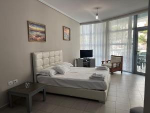 una camera con letto e TV di Lorenso Guest House a Sarandë