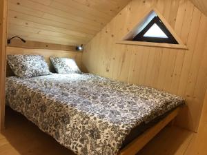 um quarto com uma cama num quarto de madeira em Apartma Povlč em Poljane nad Škofjo Loko