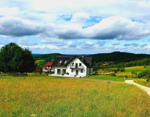 a white house in the middle of a field at Zasankowe Wzgórze in Zasań +17 photos