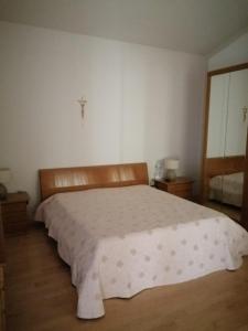 a bedroom with a large white bed with a cross on the wall at B&B dei Girasoli in Trani