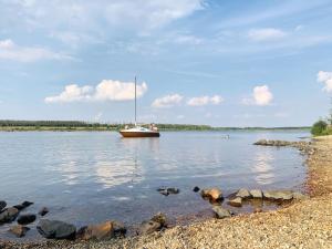 una barca seduta su un lago con rocce in acqua di Grüne Idylle in der Nähe des Zwenkauer Sees a Zwenkau