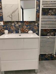 ein Badezimmer mit einem weißen Waschbecken und einem Spiegel in der Unterkunft Casa sul Corso in Cosenza