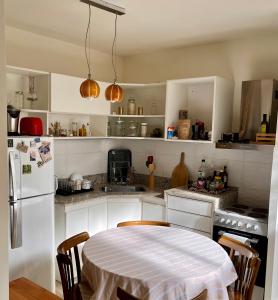 cocina con mesa y nevera blanca en Departamento/Penthouse en Belgrano en Buenos Aires