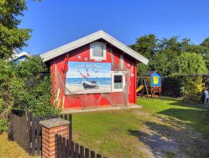 una casa roja con una pintura a un lado. en Zinnowitz, Haus Jörn en Zinnowitz