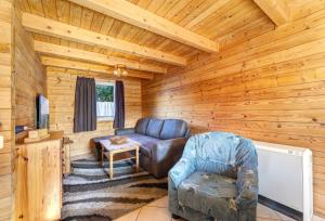 a living room with a couch and a tv in a log cabin at Zinnowitz, Haus Jörn in Zinnowitz +10 photos