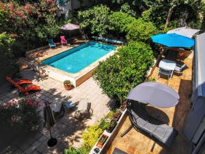 an overhead view of a swimming pool with chairs and umbrellas at Rougetomette in Nîmes
