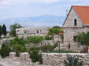 a stone building with a stone wall and a house at Augustinovi Dvori in Škrip