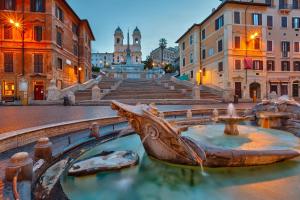 a fountain in the middle of a city with buildings at Rome Plaza Suites, Luxury Collection in Rome