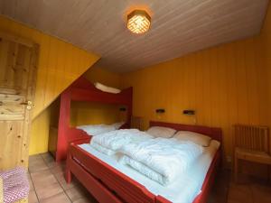 Trollbo ved Solstua في Lifjell: سرير كبير في غرفة بجدران صفراء