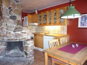 cocina con mesa y chimenea de piedra en Trollbo ved Solstua en Lifjell