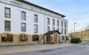 a large white building on a street at Appart-Hotel Ernz Noire in Grundhof