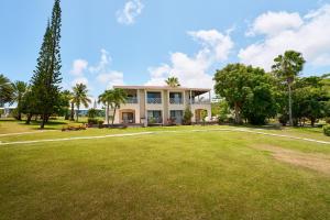 une maison avec une grande pelouse devant elle dans l'établissement Mount Nevis Hotel, à Nevis