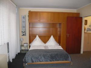 1 dormitorio con 1 cama grande y cabecero de madera en Apartment, Cuxhaven, en Döse