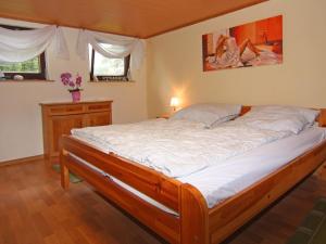 a bedroom with a large bed with white sheets at Cottage, Dolgen am See in Klein Sprenz
