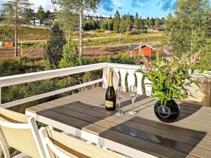 una mesa de madera con una botella de vino y dos copas en 10 person holiday home in SYSSLEB CK en Sysslebäck