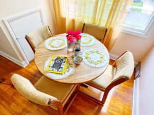 una mesa de comedor con platos y flores. en Cozy, Private Loft 15 min away from Downtown Detroit en Grosse Pointe Park