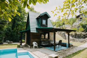 a tiny house with a pool in the yard at Koliba TAMAN in Konjic