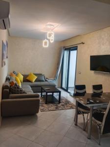 a living room with a couch and a table at SMIR PARK apartment Mdi'q , Marina smir, Oceanica in Marina Smir