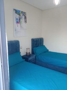 two beds in a room with blue sheets at SMIR PARK apartment Mdi'q , Marina smir, Oceanica in Marina Smir +40 photos