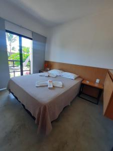 a bedroom with a large bed with towels on it at Agapanthus Apartamentos in Jericoacoara