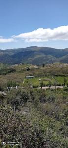 Blick auf einen Hügel mit einem Bauernhof in der Ferne in der Unterkunft Casa Rural Dunas in Santa María de la Alameda