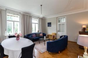 a living room with a table and blue chairs at Vila Adelaide in Brtníky