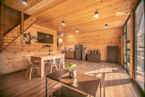 a log cabin kitchen with a table and chairs at Shaori Lake Cottages in Kharistʼvala