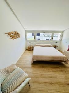 a white bedroom with two beds and a window at Marina Dream House in Lignano Sabbiadoro