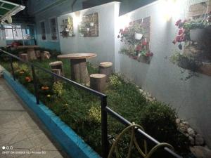 - un petit jardin avec une table et des tabourets dans un bâtiment dans l'établissement Vila Arbri7, à Pogradec