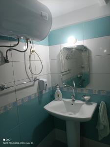 La salle de bains est pourvue d'un lavabo et d'un miroir. dans l'établissement Vila Arbri7, à Pogradec