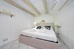 ein Schlafzimmer mit einem Bett in einem weißen Zimmer in der Unterkunft Al moretto in Rom