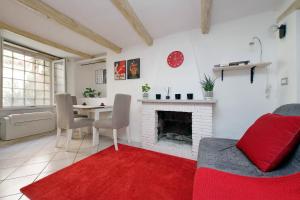 ein Wohnzimmer mit einem Kamin und einem roten Teppich in der Unterkunft Al moretto in Rom
