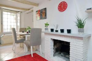 ein Wohnzimmer mit einem Kamin und einem Tisch mit Stühlen in der Unterkunft Al moretto in Rom