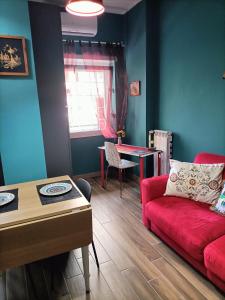 a living room with a red couch and a table at Colombo Holidays APT in Rome