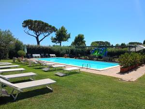 a large swimming pool with lounge chairs and a pool slide at Casale DI Tormaggiore Villa And Country Suites in Pomezia