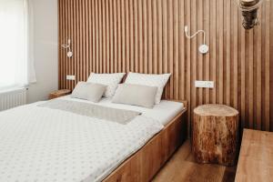 1 dormitorio con 1 cama grande y pared de madera en Apartments Triglav, en Mojstrana