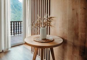 una mesa con un jarrón en una habitación en Apartments Triglav en Mojstrana