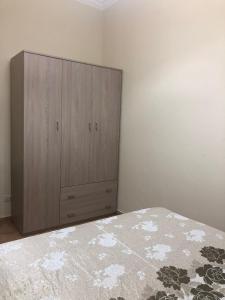 a bedroom with a bed and a wooden cabinet at AM APARTAMENT in Palermo