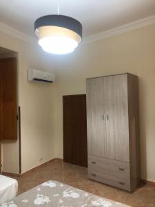 a bedroom with a bed and a cabinet and a light at AM APARTAMENT in Palermo